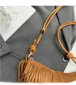 Close-up of the adjustable knotted leather strap and silver buckle on a suede fringe bag