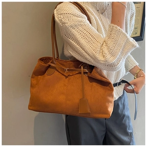Détail du sac cabas vintage en daim caramel avec boucle et texture en daim doux