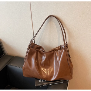 Detailed texture view of deep brown hobo tote bag in soft faux leather material