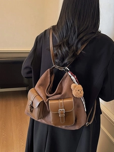 Brown suede backpack with leather pockets, printed scarf, and plush bear charm decor