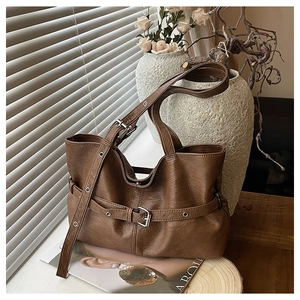 Dettaglio della borsa tote vintage marrone con fibbia decorativa e finiture argentate