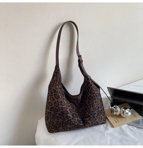 Nahaufnahme der Hobo-Tasche mit Leopardenmuster und verstellbarem Riemen am Schreibtisch