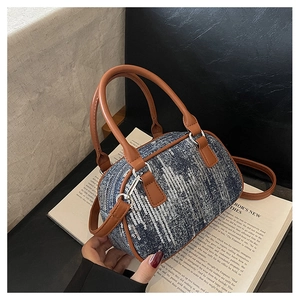 Detail of denim bag with silver sequins and brown leather handle on vintage book