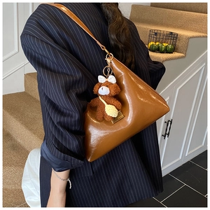 Détail d'un sac triangulaire en cuir PU marron avec un joli porte-clés ours en peluche