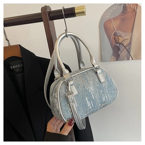 Detail showing shiny silver sequins on denim fabric with elegant metal ring handles