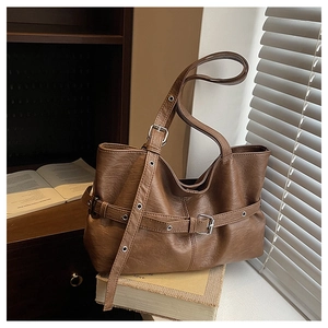 Dettaglio borsa tote vintage marrone con texture grana litchi e cinturini con fibbie