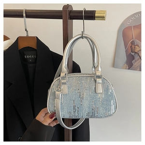Detail of light blue denim handbag with vertical sequins and silver hardware handles