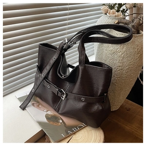 Dettaglio della borsa tote marrone scuro con occhielli in metallo e fibbia stile vintage
