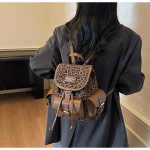 Sac à dos léopard avec garniture en cuir marron porté par un mannequin en intérieur