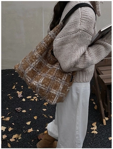 Close-up of brown and beige plaid wool tote bag with soft faux fur texture for autumn style