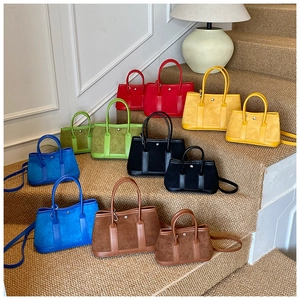 Detailed view of colorful suede bucket bags in various sizes with leather handles