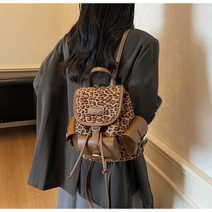 Détail du mini sac à dos léopard montrant la sangle en cuir et la boucle