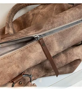 Détail du zip métallique et de la tirette en cuir sur le grand sac fourre-tout