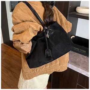 Vue détaillée du côté spacieux du sac cabas en daim noir porté par un mannequin pour le style