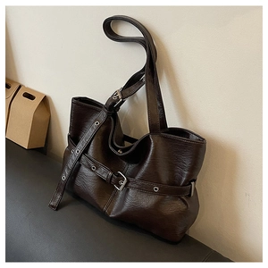 Dettaglio della borsa tote marrone scuro con texture in pelle vintage e fibbie metalliche