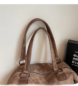 Détail des poignées en toile renforcée et des rivets métalliques d'un sac cabas brun