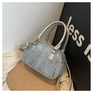 Close-up of silver sequin mini handbag with metallic handles and crossbody strap details