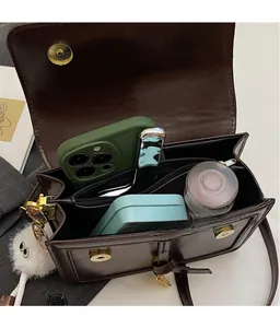 Détails de l'intérieur du sac bandoulière marron montrant les compartiments de rangement