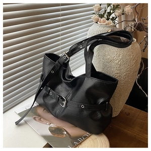 Dettaglio della borsa tote in pelle nera con fibbie in metallo argento e grana fine