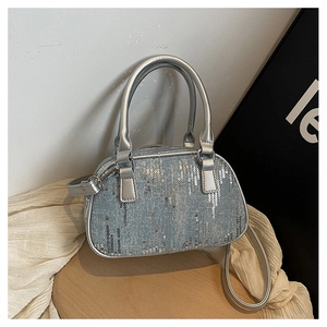 Detail of blue denim purse featuring vertical silver sequins and metallic leather handles