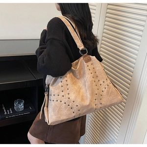 Détail du sac cabas kaki à rivets avec glands latéraux dans un décor de style de vie