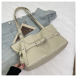Dettaglio della borsa tote in pelle off-white con superficie testurizzata e fibbia argento