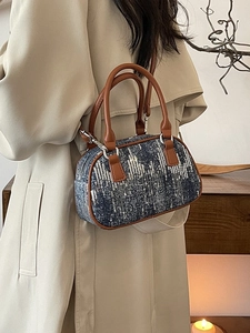 Blue sequin barrel bag with brown leather handles worn over a beige trench coat