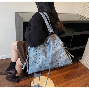 Détail du grand sac cabas en jean bleu clair avec motif étoile en rivets métalliques