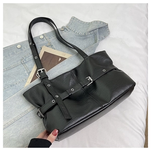 Dettaglio borsa tote in pelle PU nera con fibbie metalliche e cinturini con occhielli