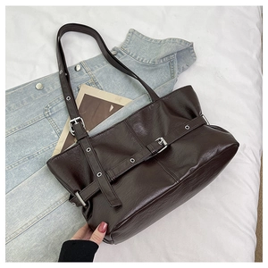 Vista dettagliata della borsa tote marrone scuro con trama in pelle vintage e fibbia decorativa