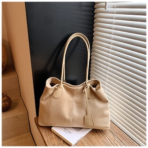 Détail du sac cabas beige en daim montrant la texture douce et la bandoulière