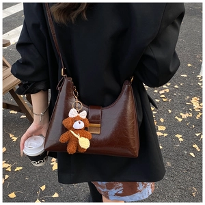 Détail du sac hobo marron foncé avec pendentif ours en peluche et boucle en métal