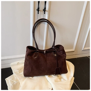 Détails du sac cabas en daim marron foncé avec poignées brillantes et pendentif épuré