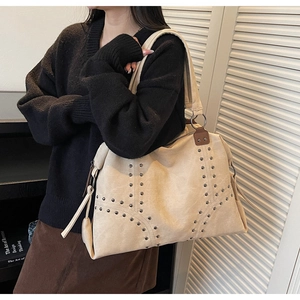 Détail du grand sac cabas beige avec rivets métalliques et texture aspect daim