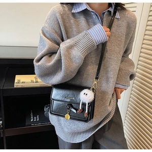 Sac bandoulière noir vintage chic avec détail de breloque poupée en peluche douce