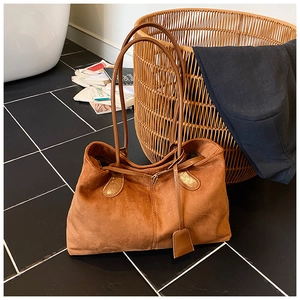 Détail du cabas en daim marron avec texture mate et doubles anses pour le quotidien