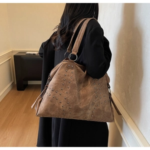 Détail du grand sac cabas en daim marron avec rivets métalliques et double bandoulière