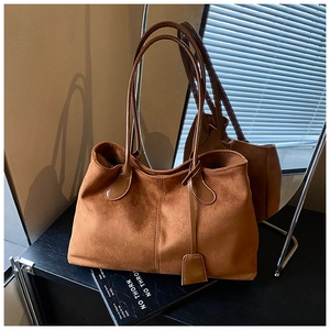 Vue détaillée du sac cabas en daim marron avec coutures renforcées et anses en cuir