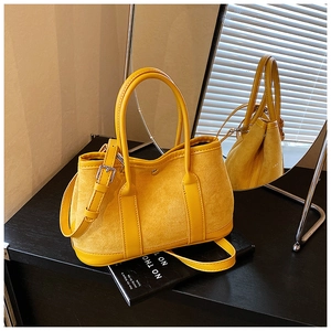 Detail showing yellow suede and faux leather tote with handles and silver metal hardware