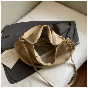 Detail of soft lychee texture and large interior of beige tote bag with gold hardware