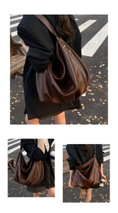 Detail view of large dark brown hobo bag with soft leather texture and vintage hardware