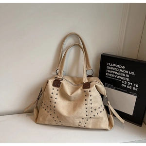 Détail du sac cabas beige orné de rivets métalliques argentés en forme d'étoile