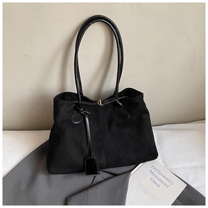 Vue détaillée du sac cabas en daim noir avec poignées en cuir verni et fermoir métal
