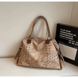 Détail du sac cabas en similicuir marron avec rivets métalliques et attaches