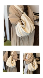 Detail of soft cream leather tote with ruched texture and gold metal stud accents