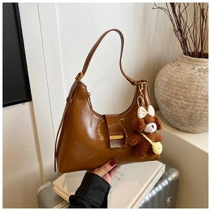 Détail du sac hobo en cuir PU ciré marron vintage avec un pendentif chien en peluche