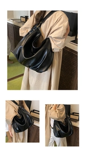 Close-up of the soft black lychee grain leather texture and metallic buckle of the tote bag
