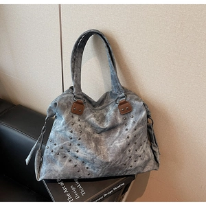 Détails des rivets métalliques et renforts cuir sur grand sac cabas gris femme