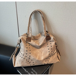Détail du sac cabas en daim kaki avec rivets métalliques et sangles en cuir marron