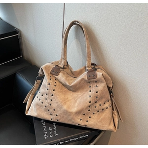 Gros plan du cabas marron vintage avec rivets métalliques et détails de franges
